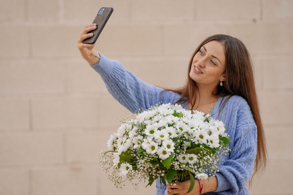 ragazza con bouquet di margherite che si scatta una foto