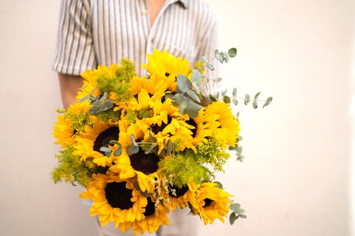 ragazza tiene in mano un mazzo di girasoli