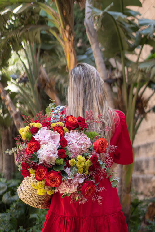 ragazza di spalle tiene un bouquet multicolor